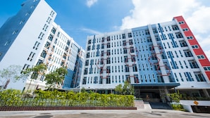 A multi-story hotel with a modern design, featuring a prominent geometric pattern on the facade. - P Plus Hotel (Pattaya)