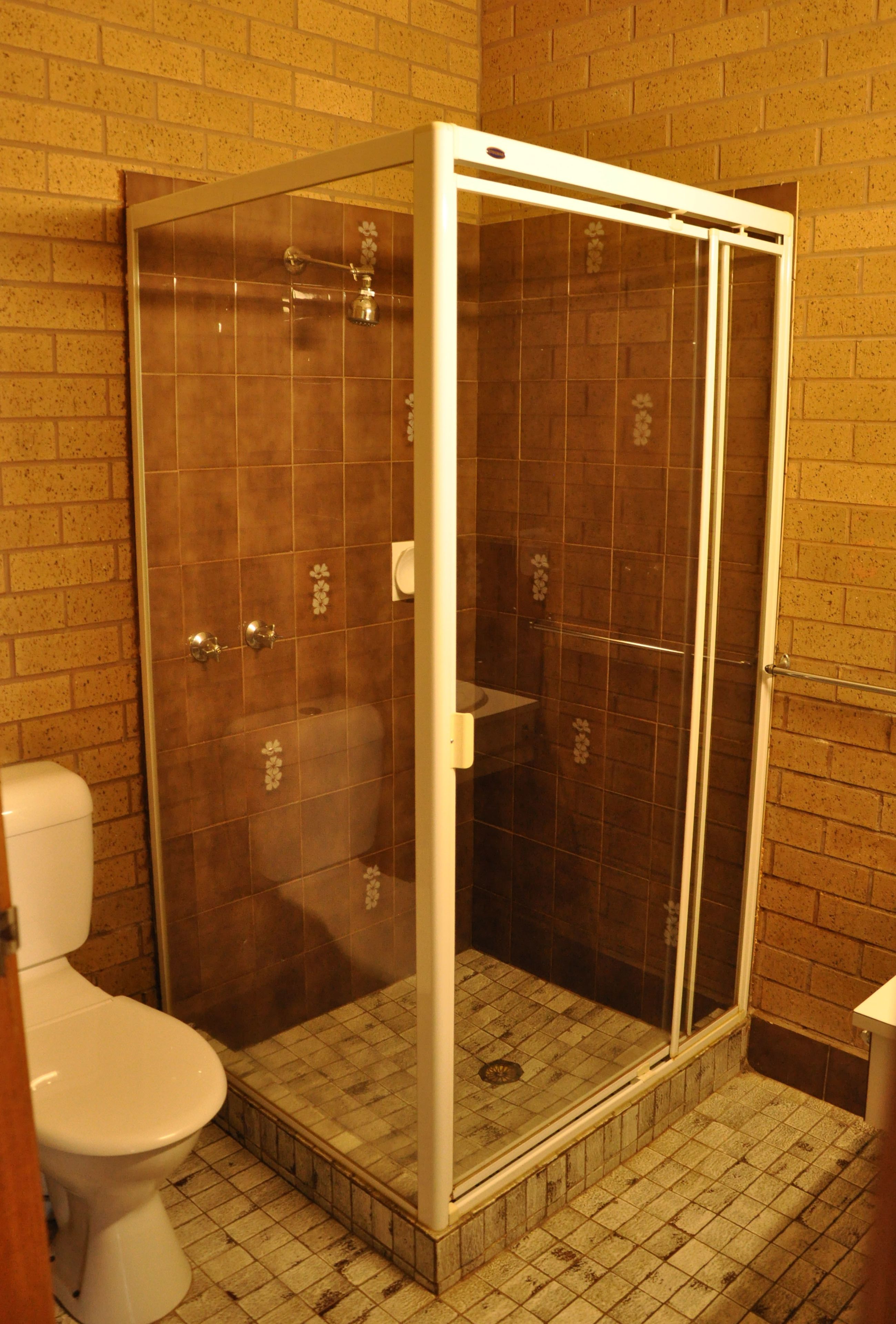 Ein Badezimmer mit Duschkabine, Toilette und Waschbecken.