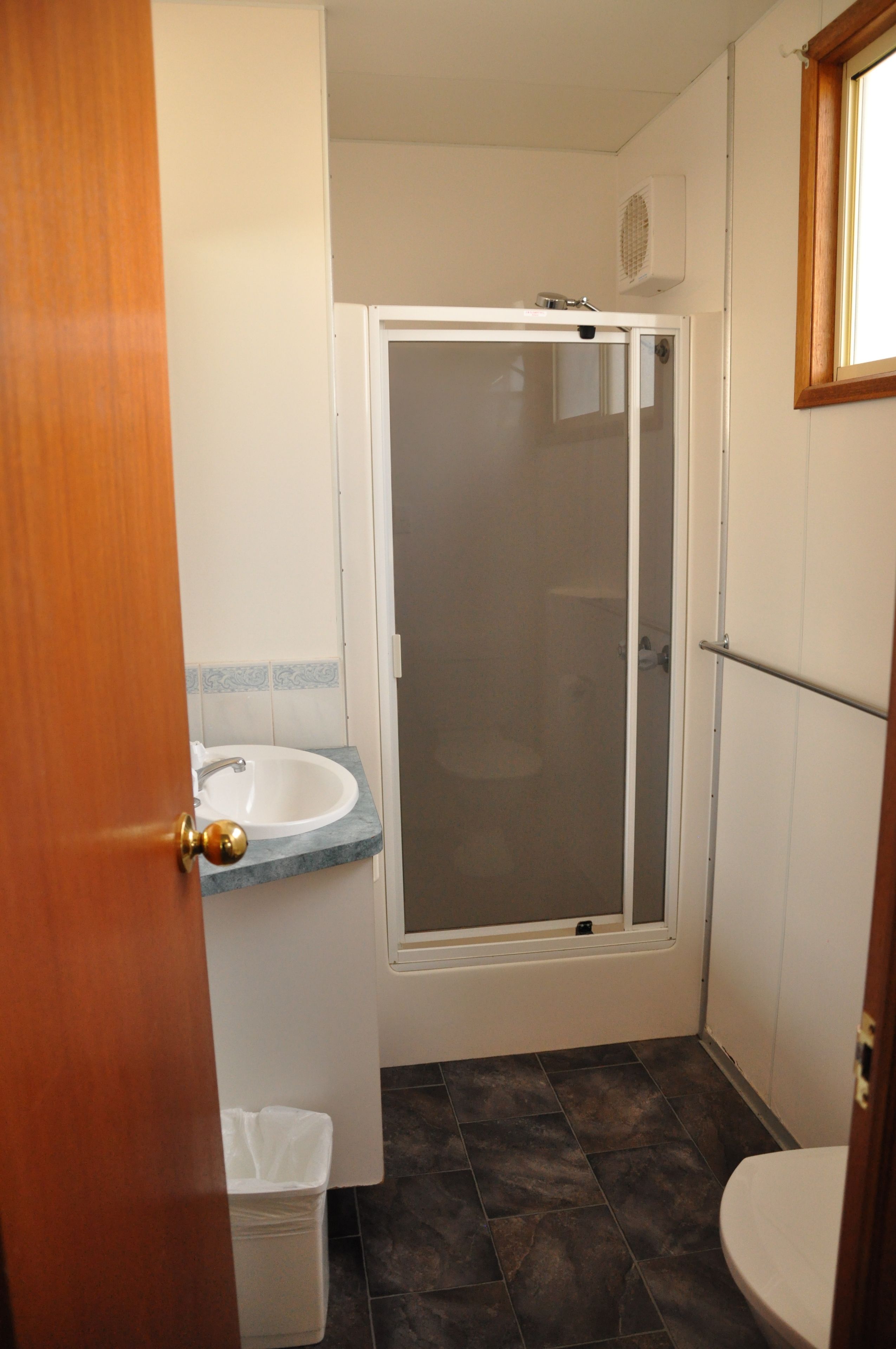 Un baño con ducha, lavabo e inodoro.