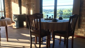 Comedor con pared de ladrillo, ventanas amplias y vista a zonas verdes.
