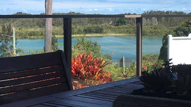 Un banco de madera con vista a un lago y el paisaje circundante.