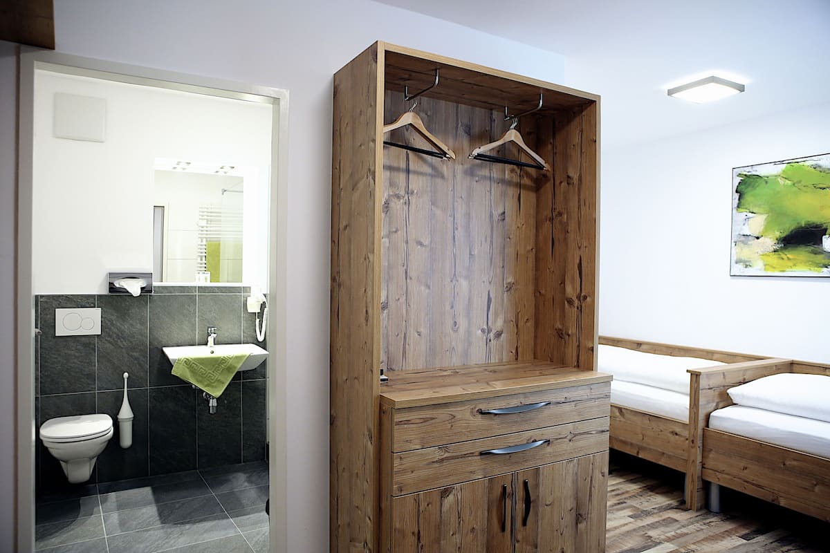 Une salle de bain moderne avec une armoire en bois, un lavabo et un lit.