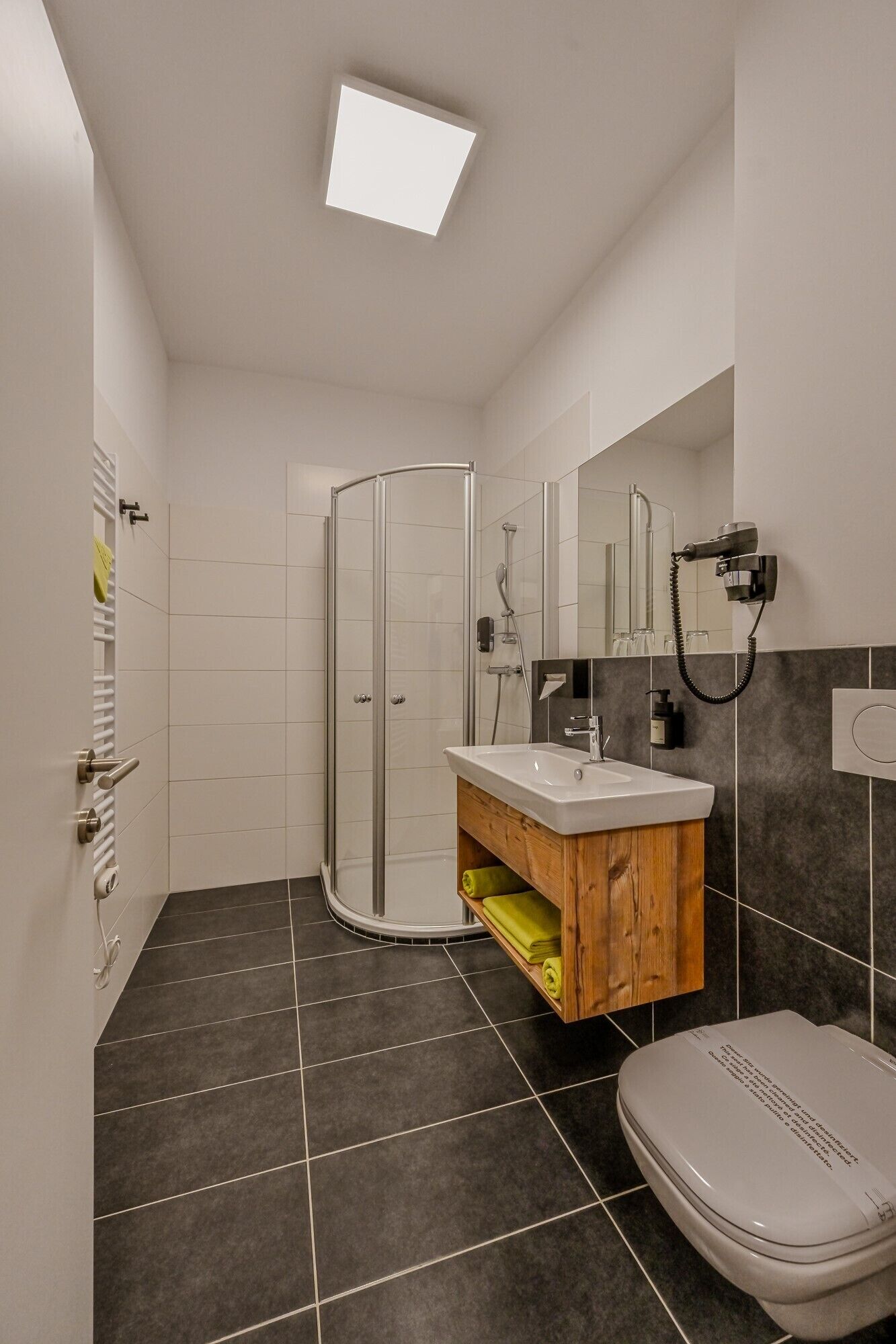A modern bathroom with a shower, sink, and toilet.