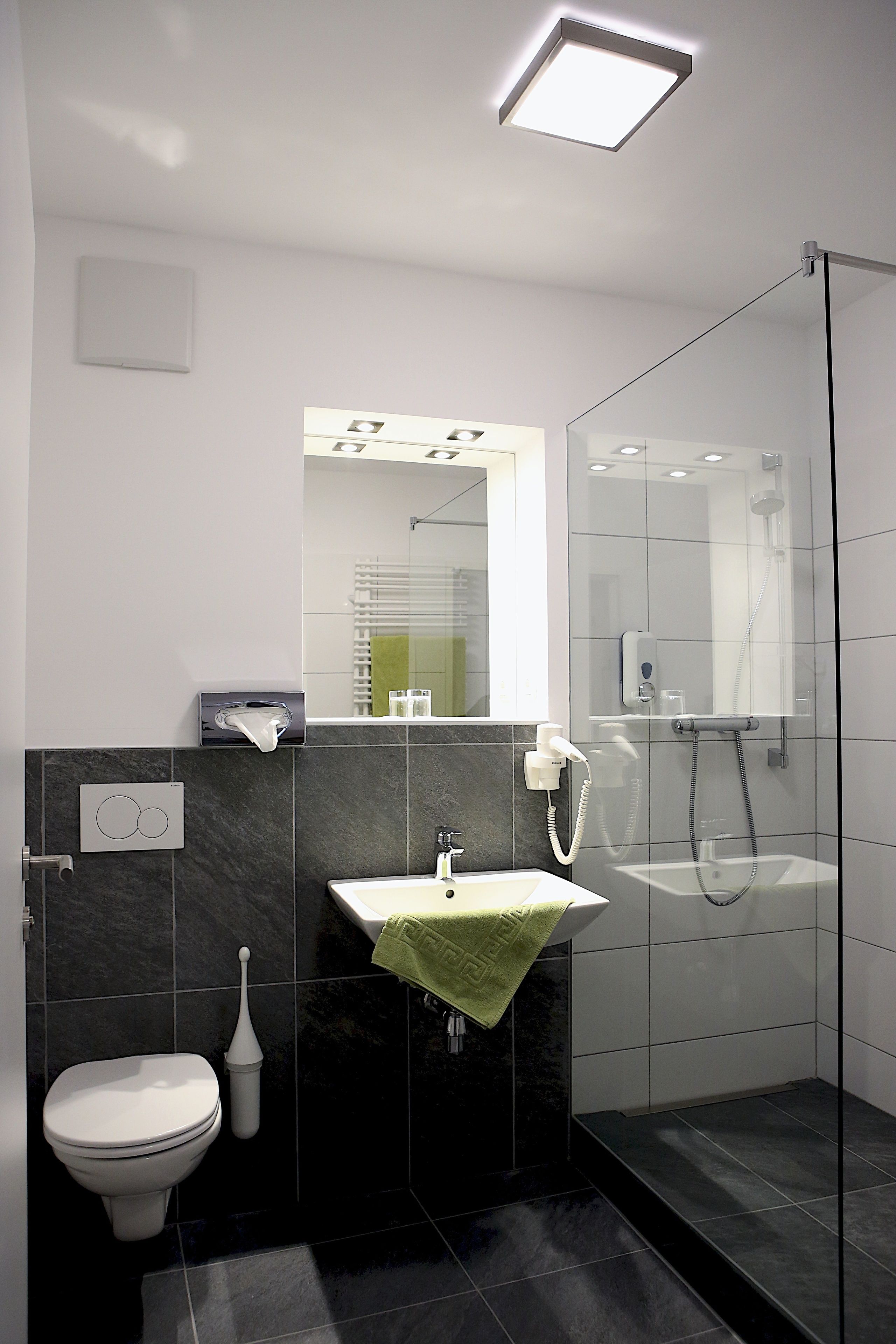 A modern bathroom with a toilet, sink, and shower.