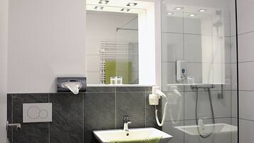 A modern bathroom with a toilet, sink, and shower.