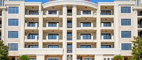 Un edificio de varios pisos con una entrada central, balcones y un cartel que dice "GARDENIA PALACE".
