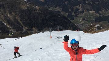 A ski slope with a chairlift and a skier in the foreground.