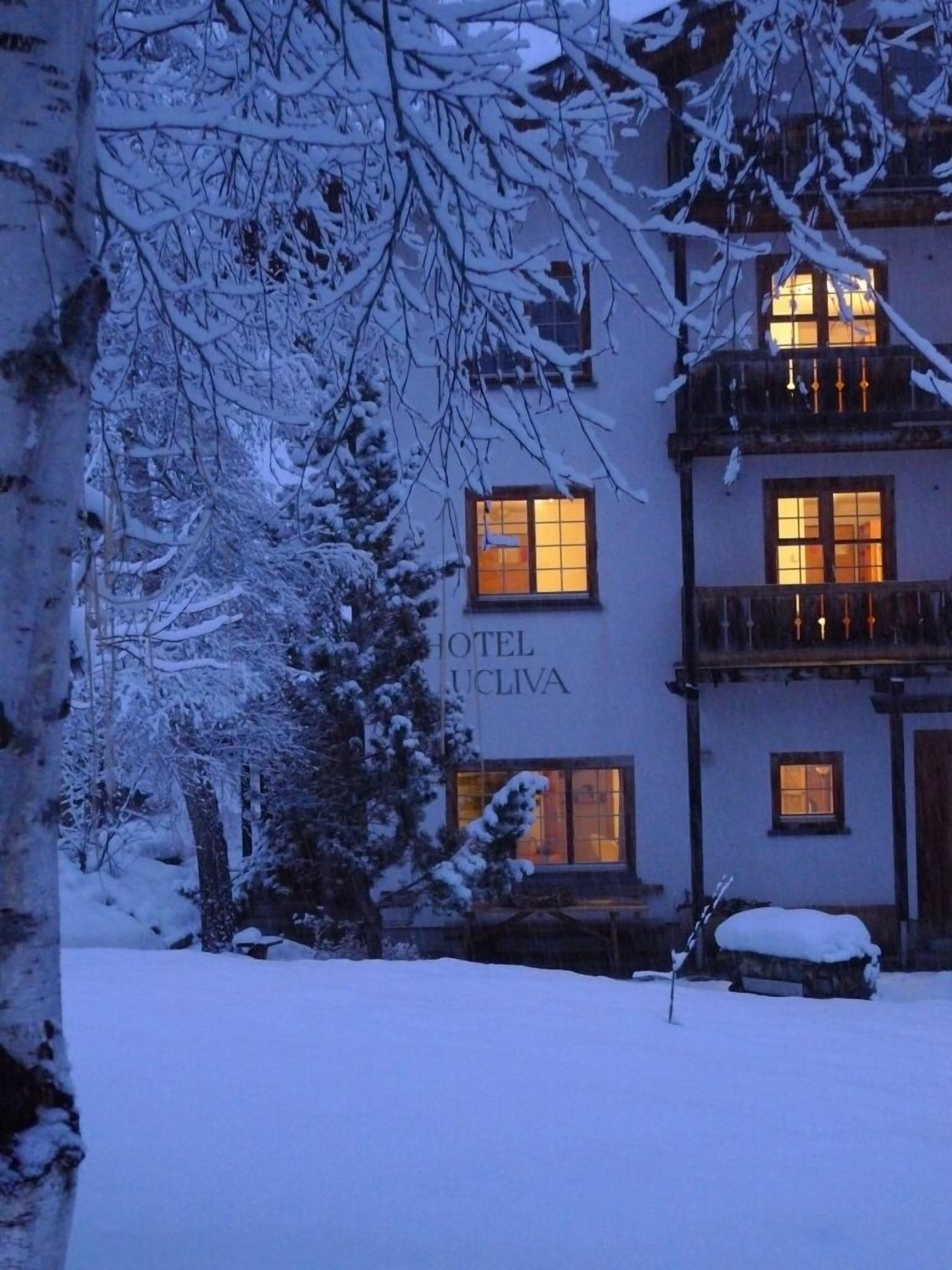 Um edifício coberto de neve com uma placa que diz 'HOTEL LUCLIVA'.