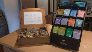 A wooden box with compartments containing various tea bags, and a display case with multiple tea bags labeled with different names.