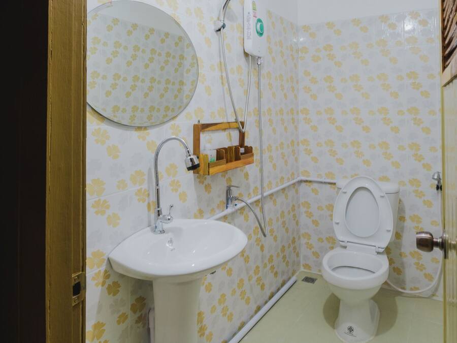 Een badkamer met toilet, wastafel en spiegel.