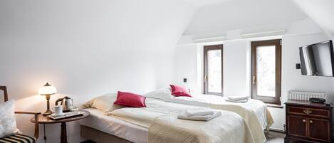 Une chambre avec deux lits, une table de chevet avec une lampe, une chaise et une commode.