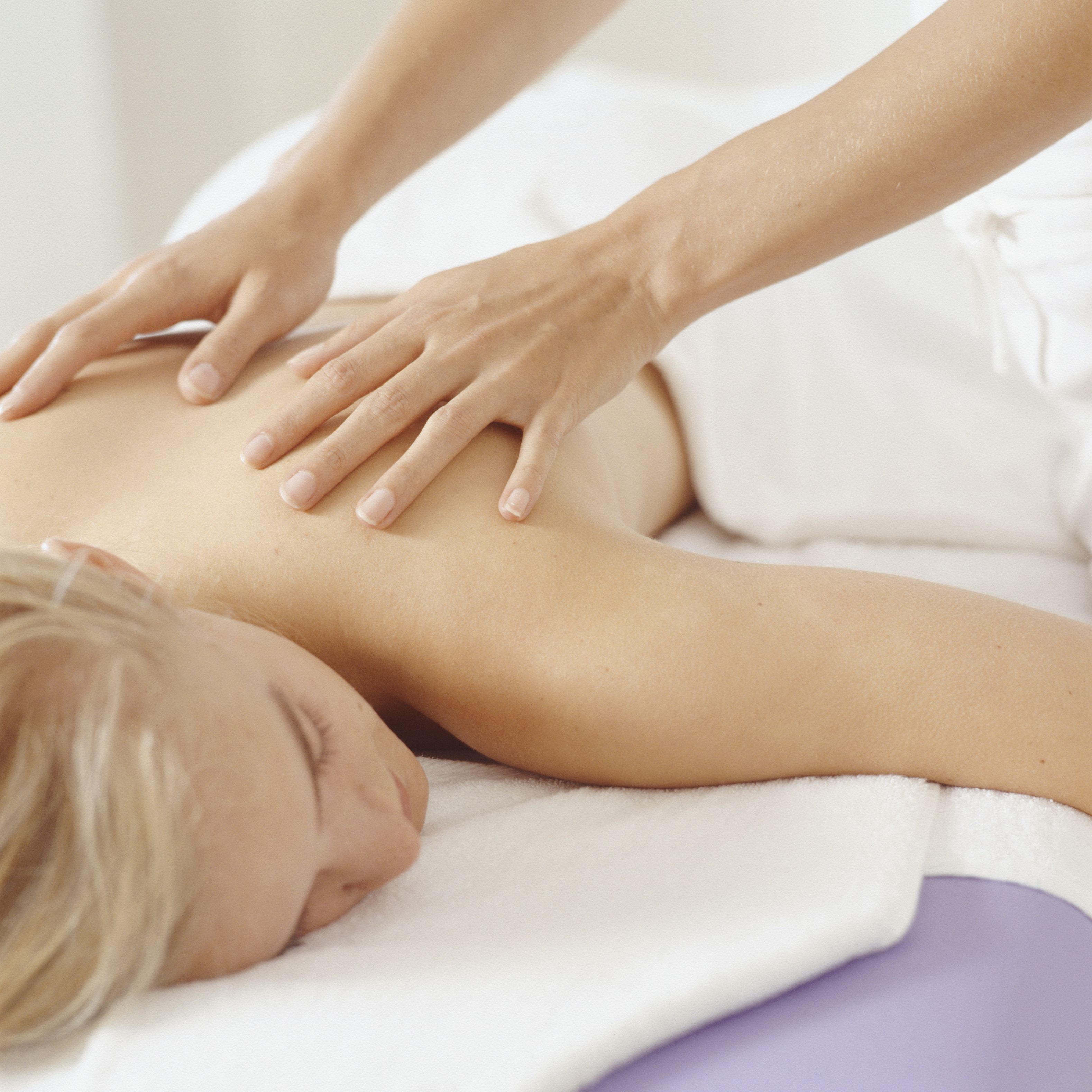 A person receiving a massage on a white towel.