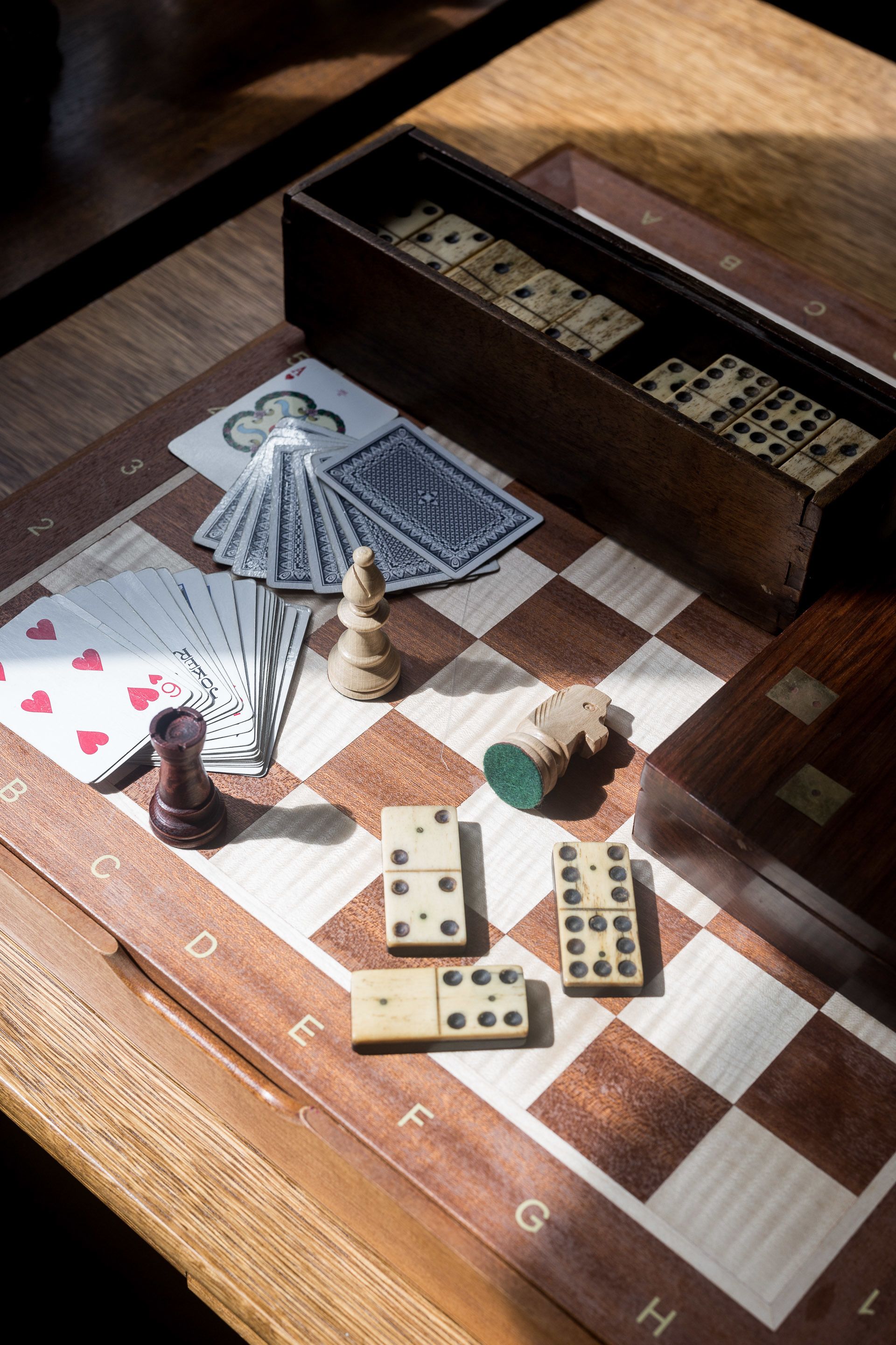 A checkered game board with chess pieces and dominoes.