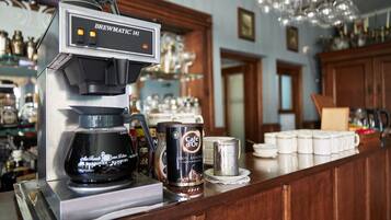 Een koffieapparaat met de aanduiding 'Brewmatic 141' en een voorraadbus 'Cafe d'Or' koffie.