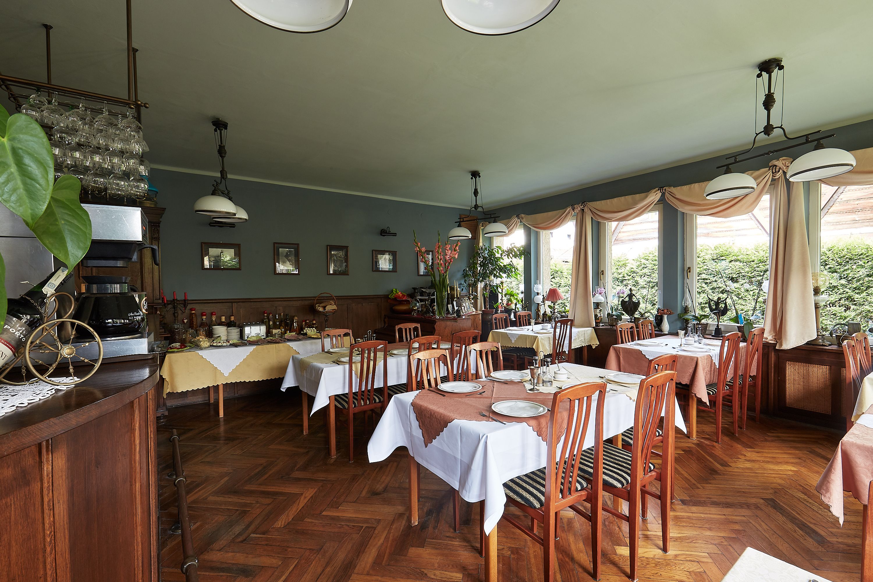 Un restaurante con pisos de madera, manteles blancos y sillas de madera.