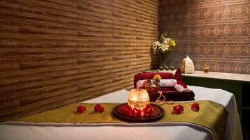 Experience ultimate relaxation in this serene spa room, featuring a plush bed, elegant table settings, and soothing ambiance.