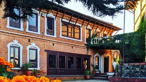 A brick building with large windows and a covered porch. - Hotel Himalayan Horizon (Dhulikhel)