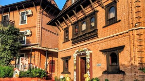 A historic building with a courtyard, brick walls, and a red door. - Hotel Himalayan Horizon (Dhulikhel)