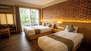 A hotel room with two beds, a balcony, and a brick wall. - Hotel Himalayan Horizon (Dhulikhel)
