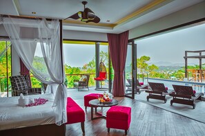 A spacious room with a bed, a balcony with a pool, and a view of greenery and mountains. - Grand Villa Luxury Time Phuket (Choeng Thale)