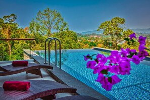 An infinity pool with a clear view of the surrounding landscape, including trees and distant hills. - Grand Villa Luxury Time Phuket (Choeng Thale)