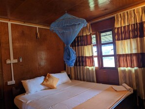 A room with a bed, a blue mosquito net, and curtains. - Sunntop Cabana (Trincomalee)