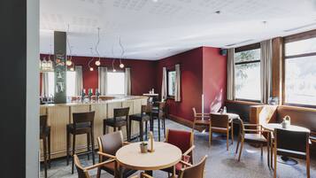 Un restaurante con bar, zona de estar y amplias ventanas.