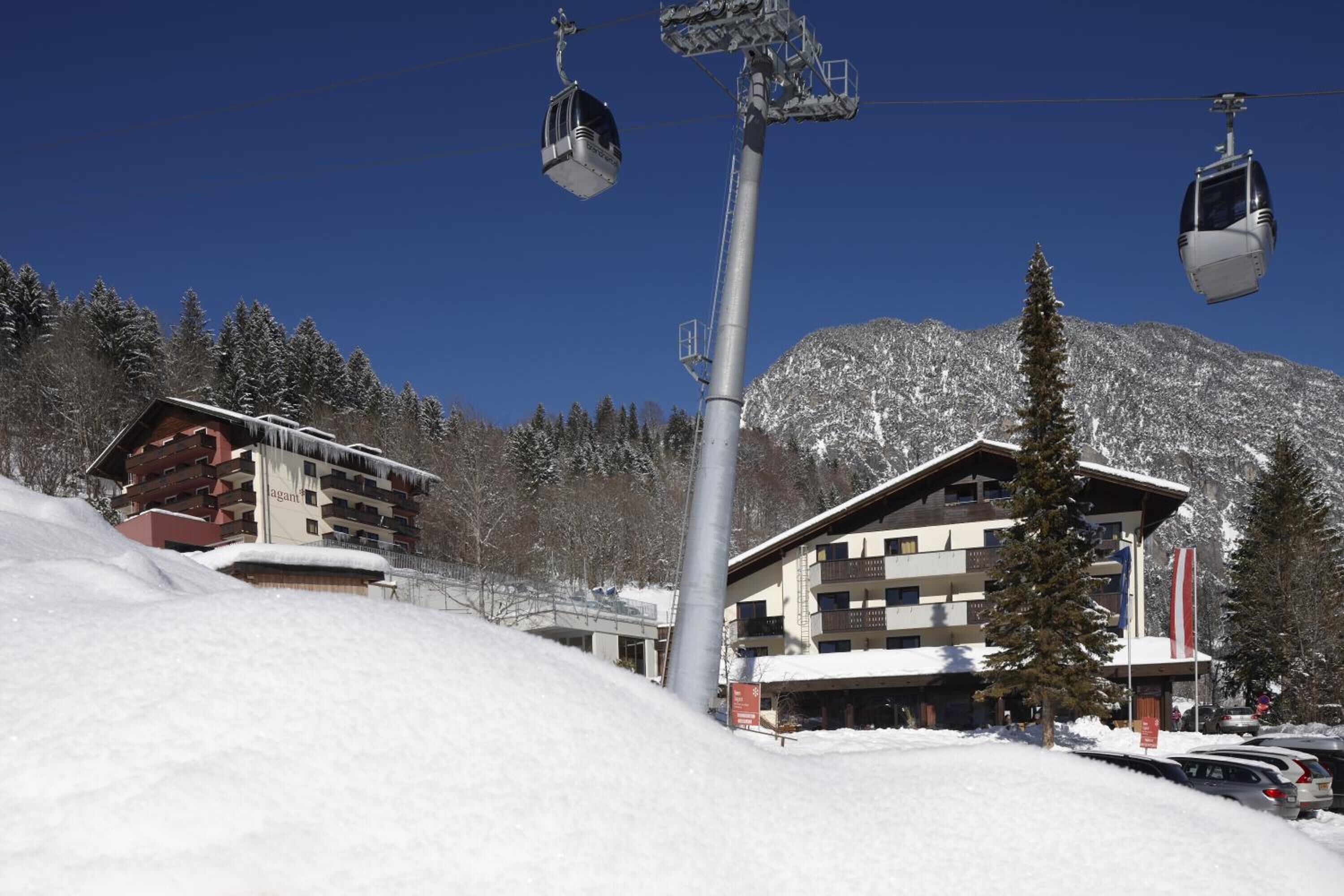 Une station de ski dotée d’un réseau de téléphériques, de bâtiments enneigés et offrant une vue imprenable sur les montagnes.