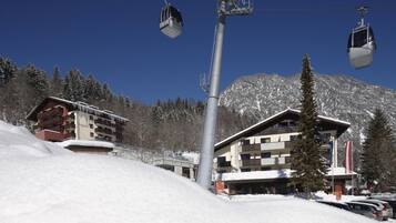 Une station de ski dotée d’un réseau de téléphériques, de bâtiments enneigés et offrant une vue imprenable sur les montagnes.