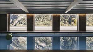 Piscina com vista para uma cadeia montanhosa arborizada.