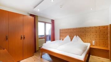 Un dormitorio con una cama de madera, un armario y cabecera de madera.
