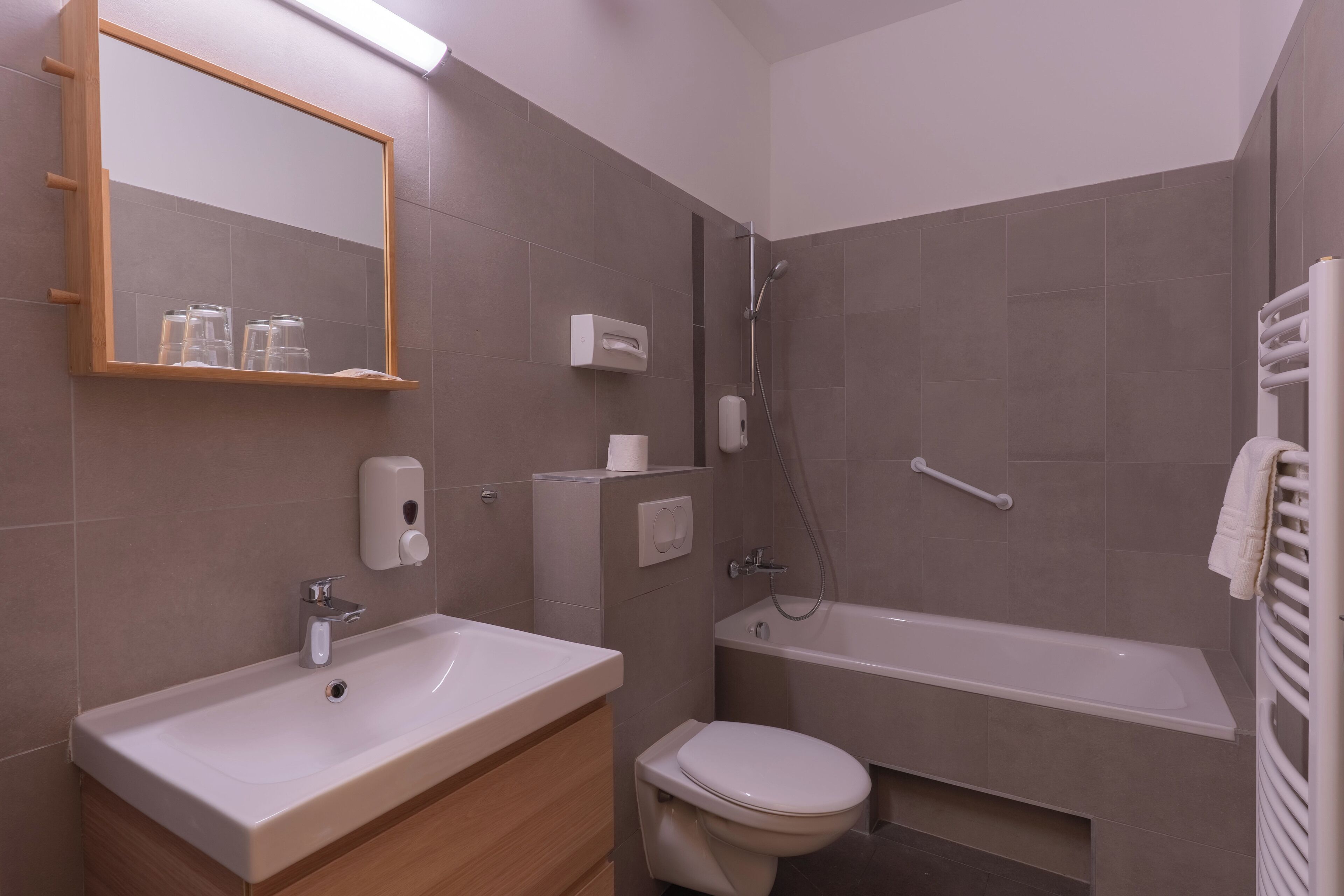 Ein modernes Badezimmer mit Waschbecken, Toilette und Badewanne.