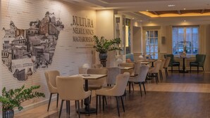 Un restaurant avec un mur décoré d’une fresque en briques, un plafond en bois et un mobilier moderne.