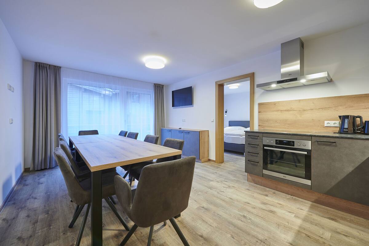 Habitación de hotel con comedor, kitchenette y una cama.