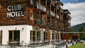 A Club Hotel with outdoor seating and a wooden facade. - Club Hotel am Kreischberg (Sankt Georgen am Kreischberg)