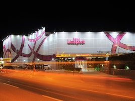 Un gran edificio de hotel con un llamativo letrero que dice 'hotel' y un diseño distintivo en rosa y blanco.