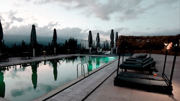 Una piscina al aire libre de temporada, sombrillas