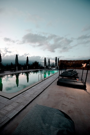Una piscina al aire libre de temporada, sombrillas