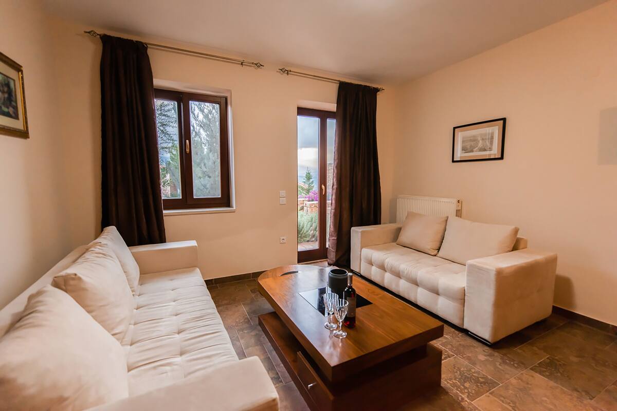 A modern living room with a sofa, a coffee table, and a window with curtains.