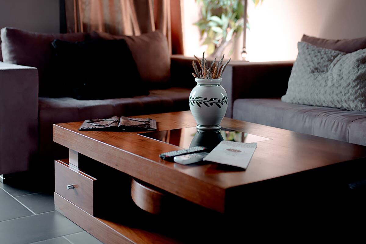 A modern living room with a sofa, a coffee table, and a lamp.
