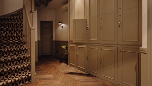 A hallway with patterned carpet, wooden flooring, and beige lockers. - Adam Downtown (Amsterdam)