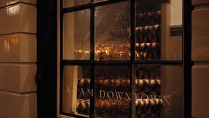 A window with the text "AM DOWN TOWN" and a view of patterned furniture inside. - Adam Downtown (Amsterdam)