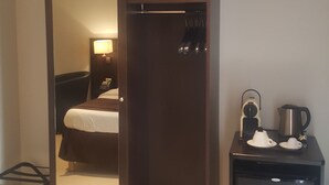 A hotel room with a bed, a desk with a coffee maker, and a mirror. - Hôtel M'lys (Conakry)