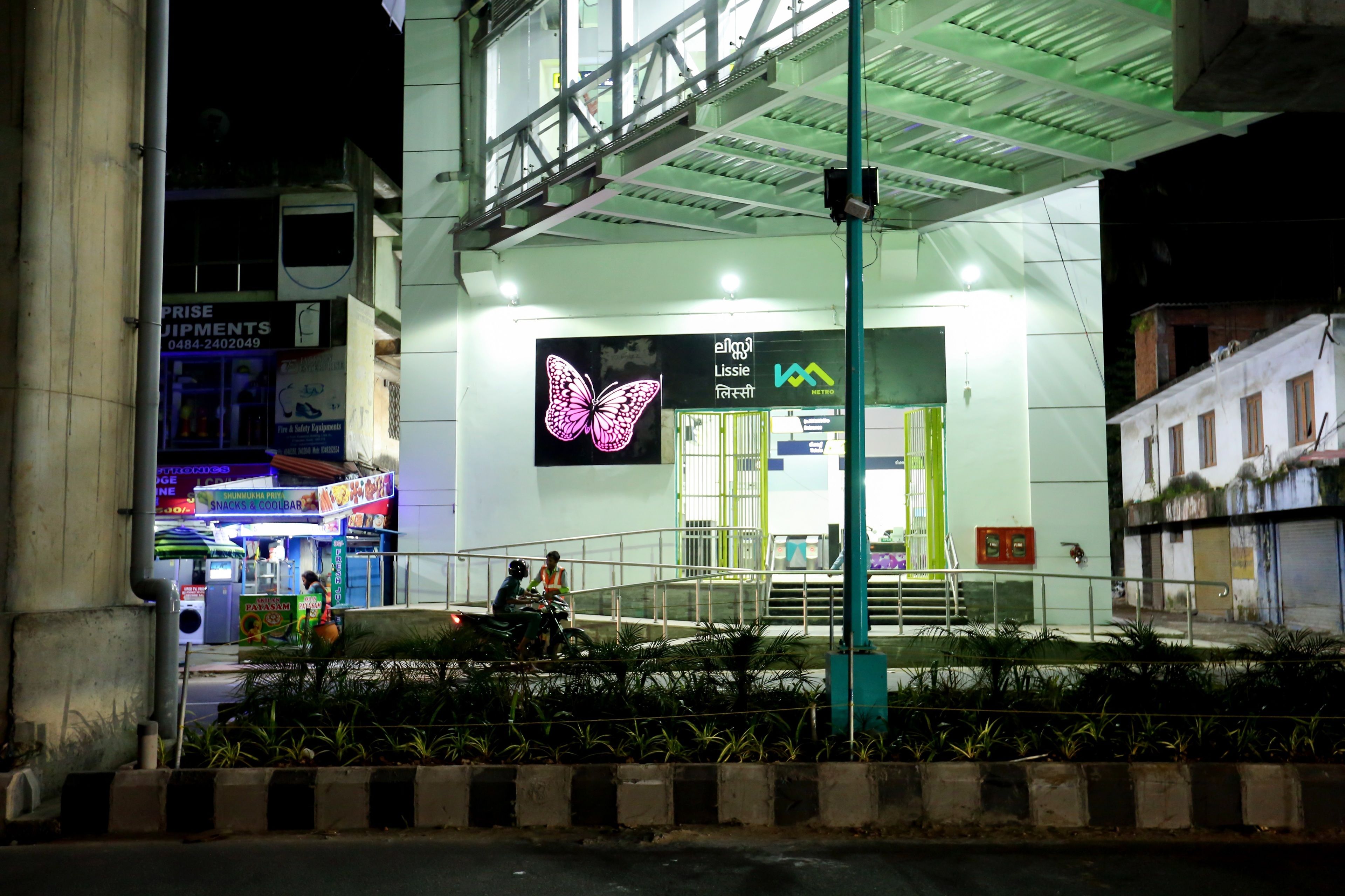 A building with a butterfly sign, a staircase, and a green railing.
