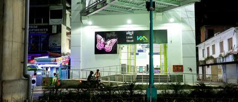 A building with a butterfly sign, a staircase, and a green railing.