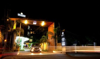 Un edificio con un letrero que dice "idno pristine" y un coche circulando por la entrada.