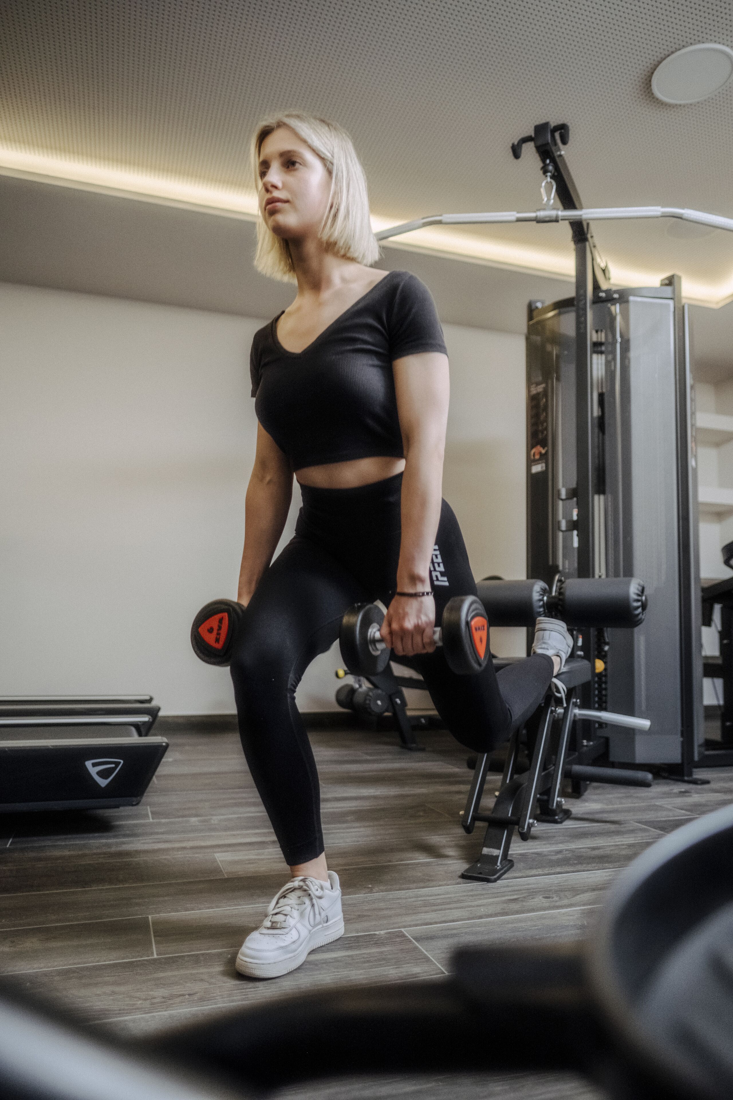 A gym with exercise equipment, including dumbbells and a weight bench.