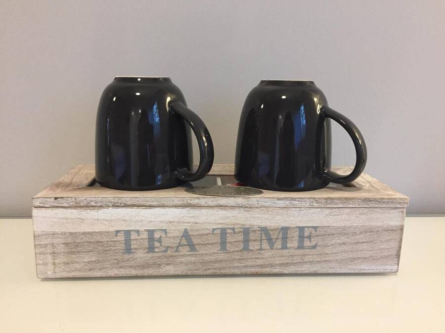 Two black mugs on a wooden tray with the words "TEA TIME" engraved on it.