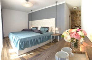 Un dormitorio con cama, mesita de noche y un jarrón de flores.