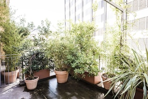 Een balkon met potplanten en uitzicht op een gebouw.